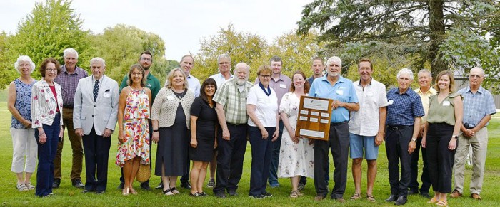 Soil innovators receive award with trees in background.