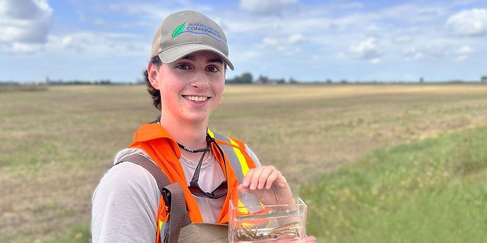Ben Harter, Junior Conservationist, in front of a field.
